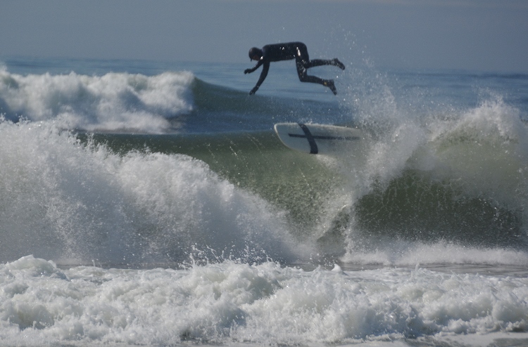 surfer in air above wave